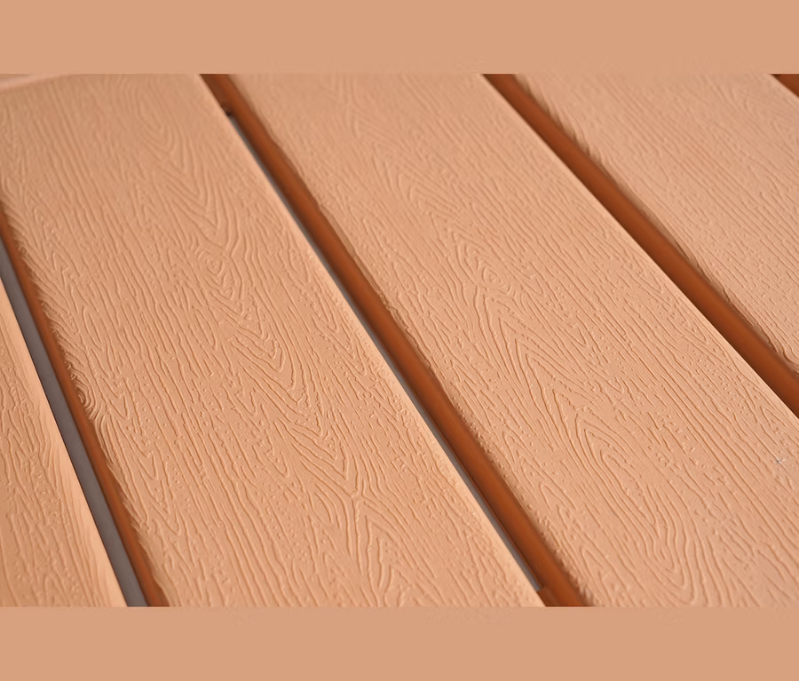 Nahaufnahme von hellbraunen Latten mit Holzmaserung, parallel angeordnet mit dunkelbraunen Zwischenräumen.