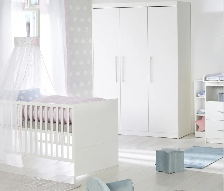 Ein Kinderzimmer mit einem weißen Kinderbett, einer breiten Wickelkommode und einem dreitürigen Schrank des roba Kinderzimmer-Sets »Maren«.