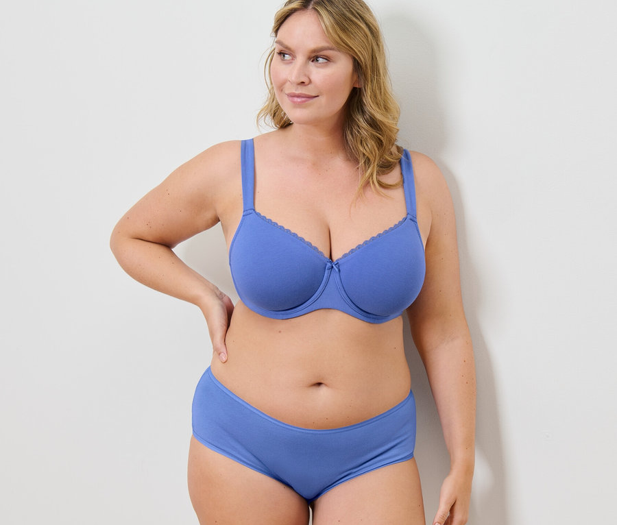 Frau posiert in blauem Bügel-BH und Höschen.