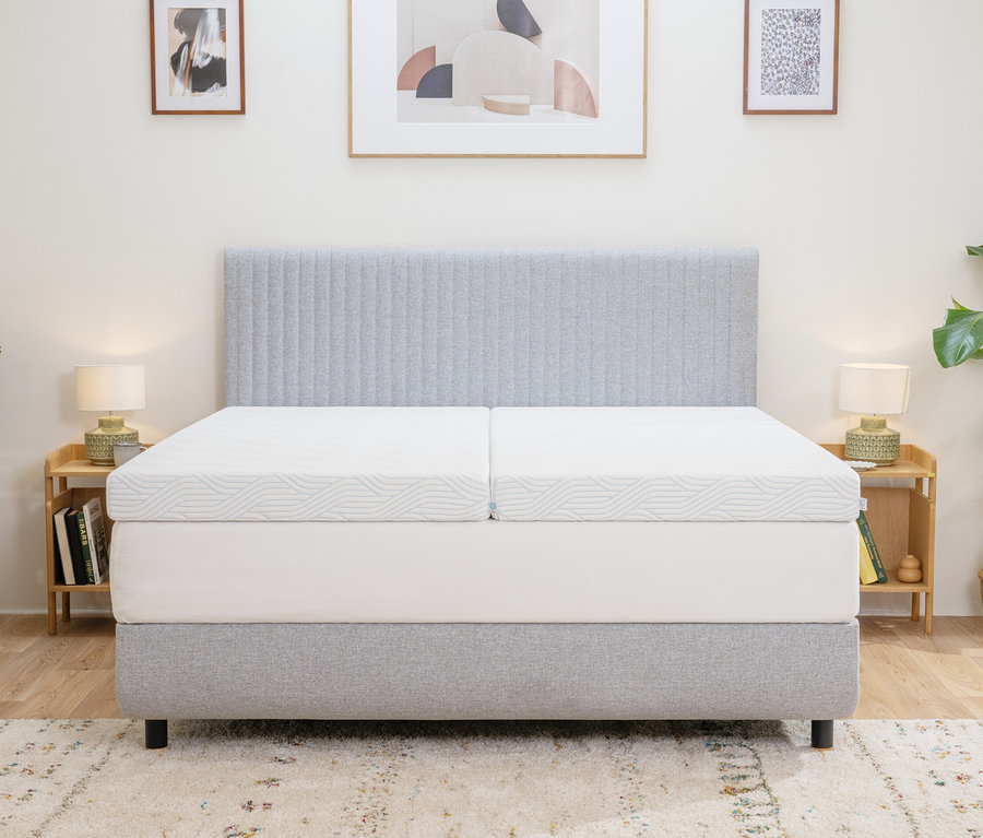 Zwei TEMPUR Pro® Plus SmartCool™ Topper liegen nebeneinander auf einem Bett mit grauem Kopfteil.