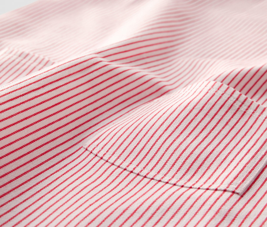 Detailaufnahme eines Kinder-Web-Latzkleides mit roten Streifen und Tasche.