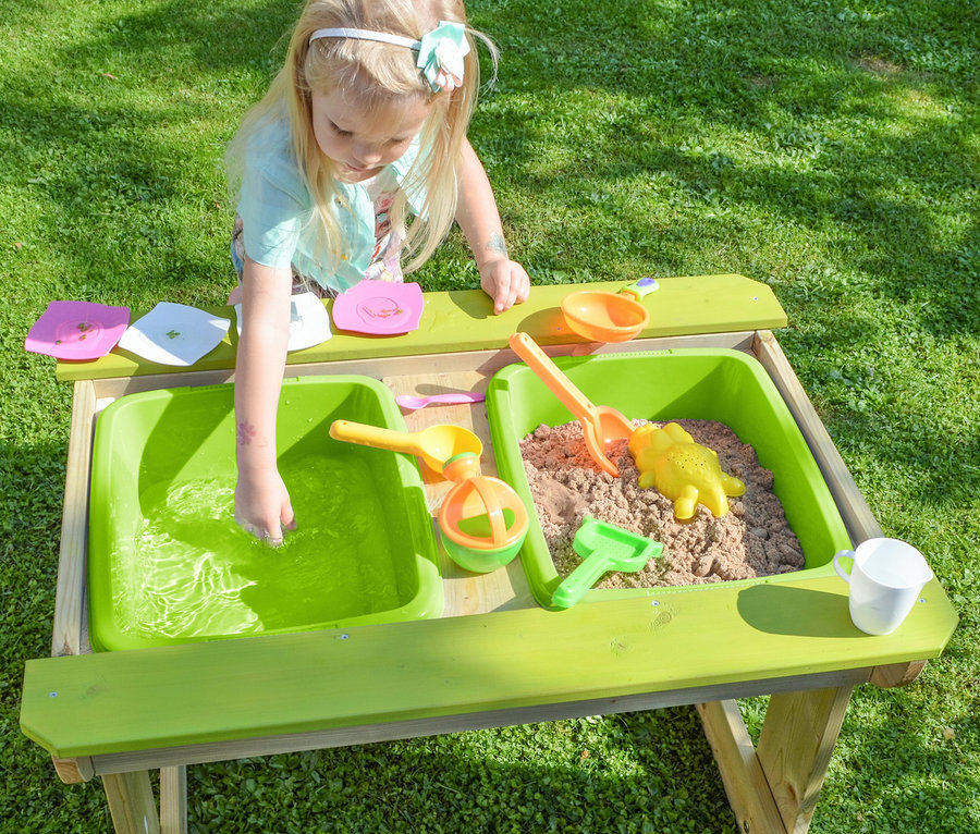 Mädchen spielt mit Wasser und Sand am Wendi Picknick- und Matschtisch mit Bänken.