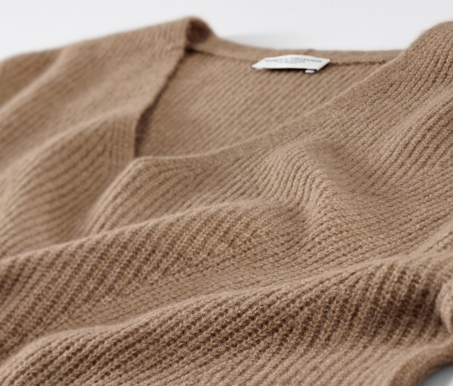 Detailaufnahme eines camel Grobstrickpullovers.