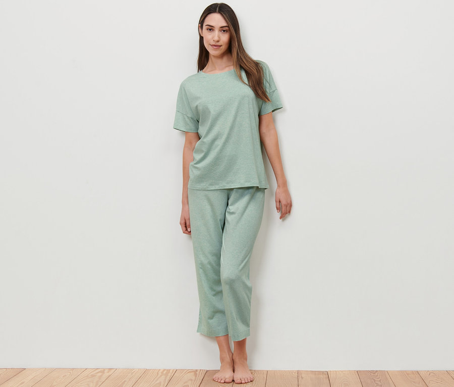 Frau posiert in mintfarbenem Pyjama.