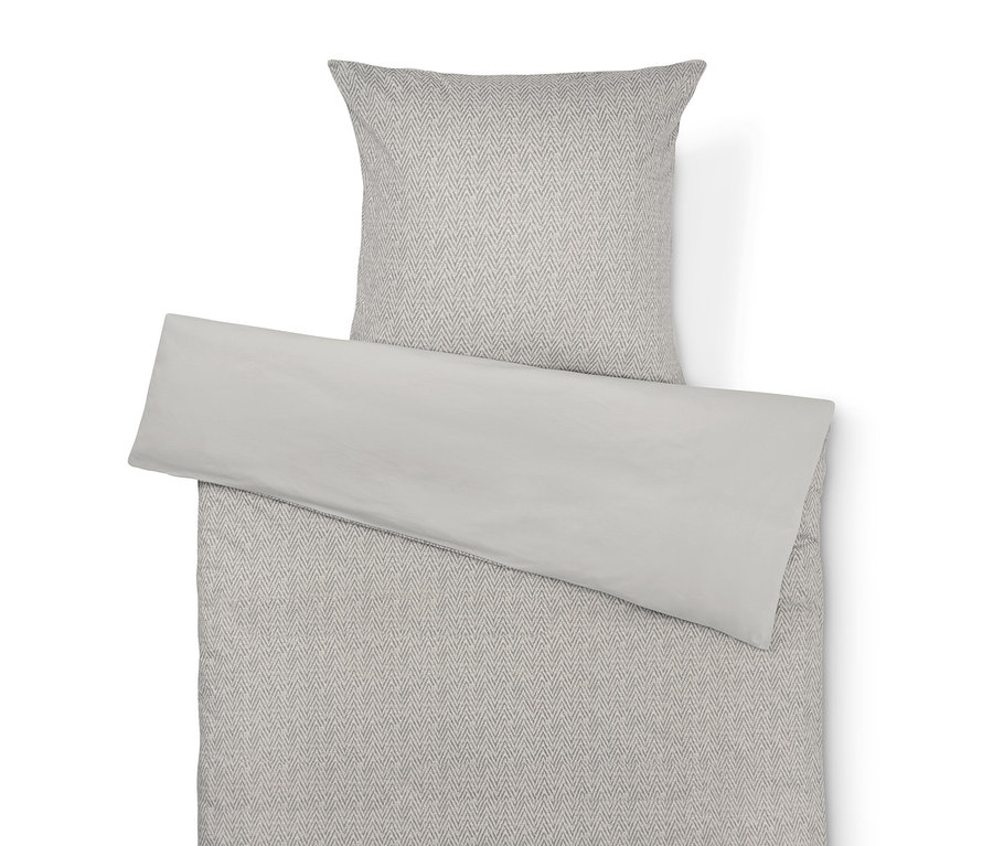 Beige Bettwäsche mit grauem Fischgrätenmuster und einfarbig beiger Kissenbezug.