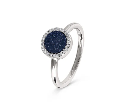 Detailaufnahme eines silbernen Rings mit einem dunkelblauen, runden Stein, der von klaren Steinen umgeben ist.