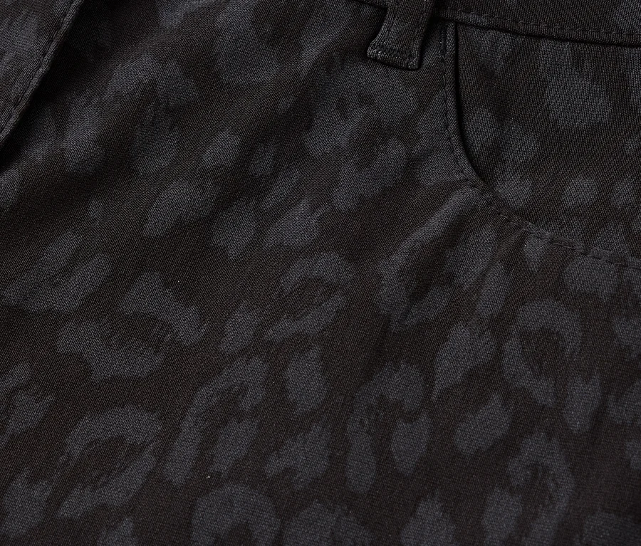 Detailaufnahme einer schwarzen Hose mit Leopardenmuster, inklusive Knopf und Tasche.