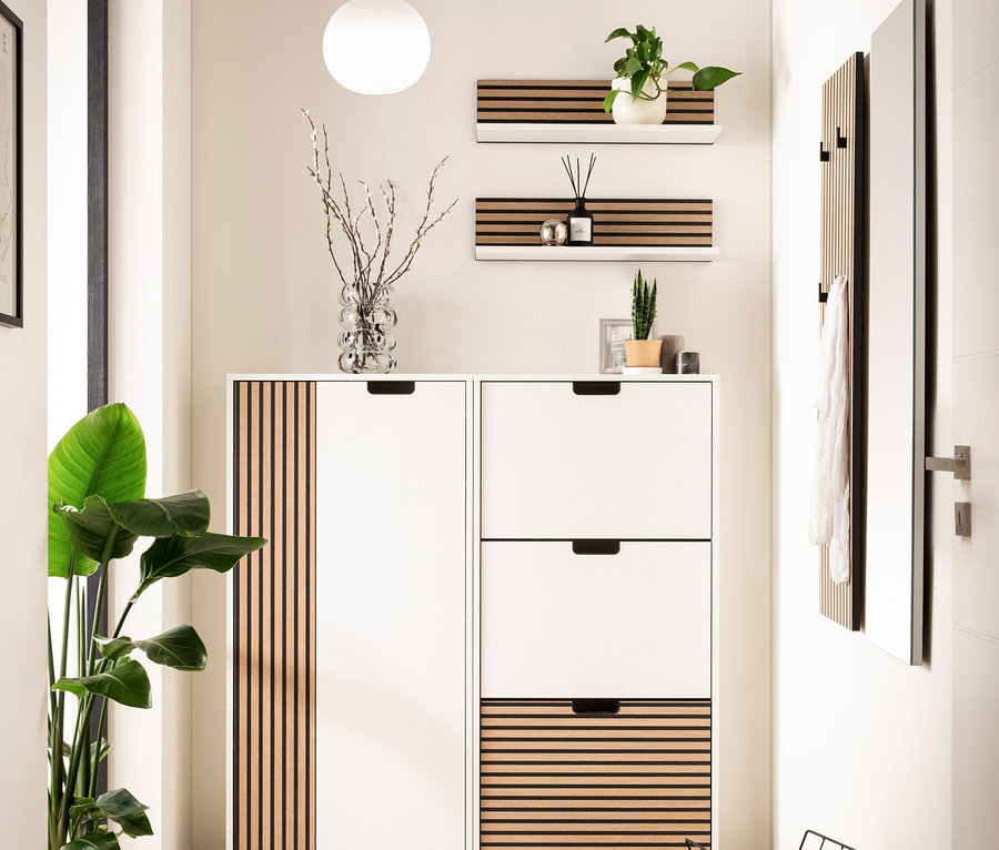 Eingangsbereich mit weißem Schuhschrank mit Holzlamellen, Regalen und Spiegel.