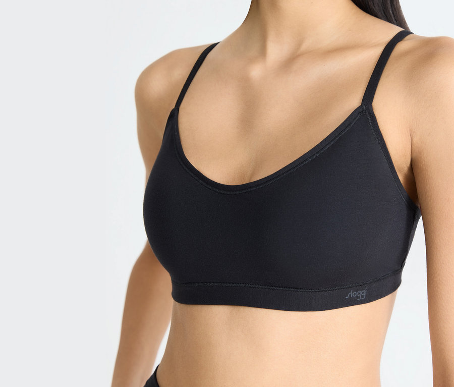 Frau trägt einen schwarzen Sport-BH.