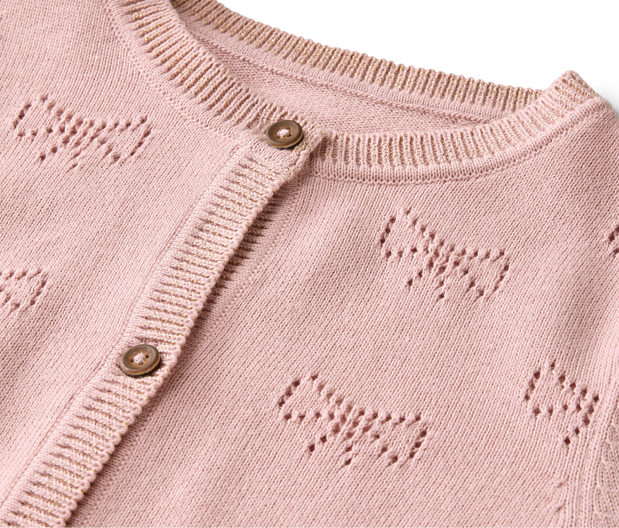 Detail einer rosa Strickjacke mit Knöpfen und Schleifenmuster.