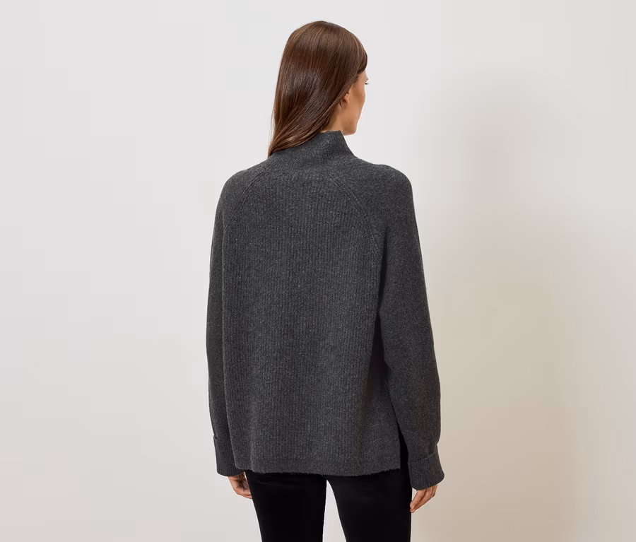Frau mit dem Rücken zur Kamera trägt einen grauen Pullover.