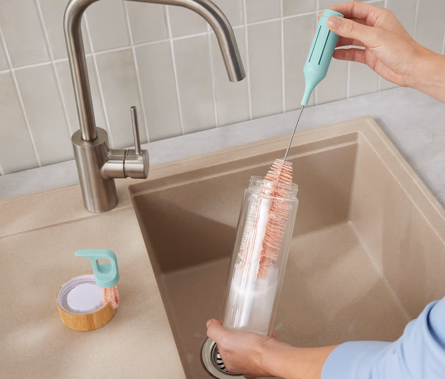 Eine Frau reinigt eine Flasche mit der 3-in-1-Gläser-und-Flaschenspülbürste.