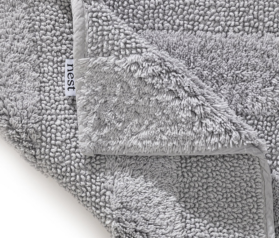 Nahaufnahme eines grauen, flauschigen Nest-Handtuchs mit grauer Bordüre.