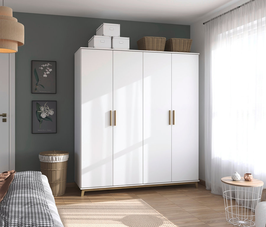 Ein rauch Kleiderschrank »Carlsson« mit Drehtüren ist im Schlafzimmer zu sehen.