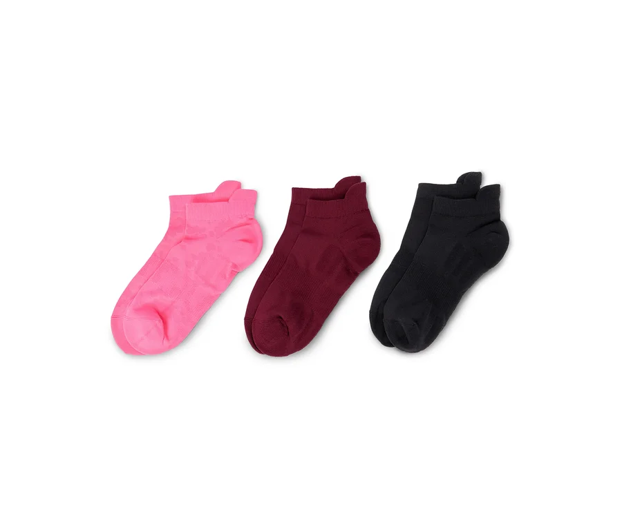 Drei Paar Socken in Pink, Burgunderrot und Schwarz liegen nebeneinander auf einem weißen Hintergrund.
