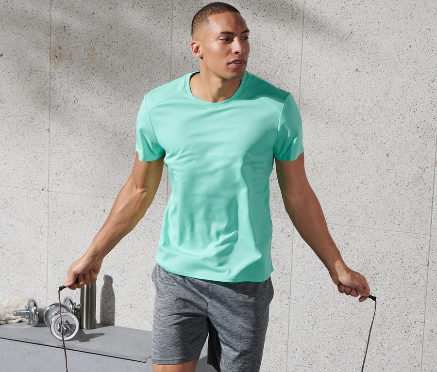 Mann springt Seil und trägt ein mintfarbenes Sportshirt.