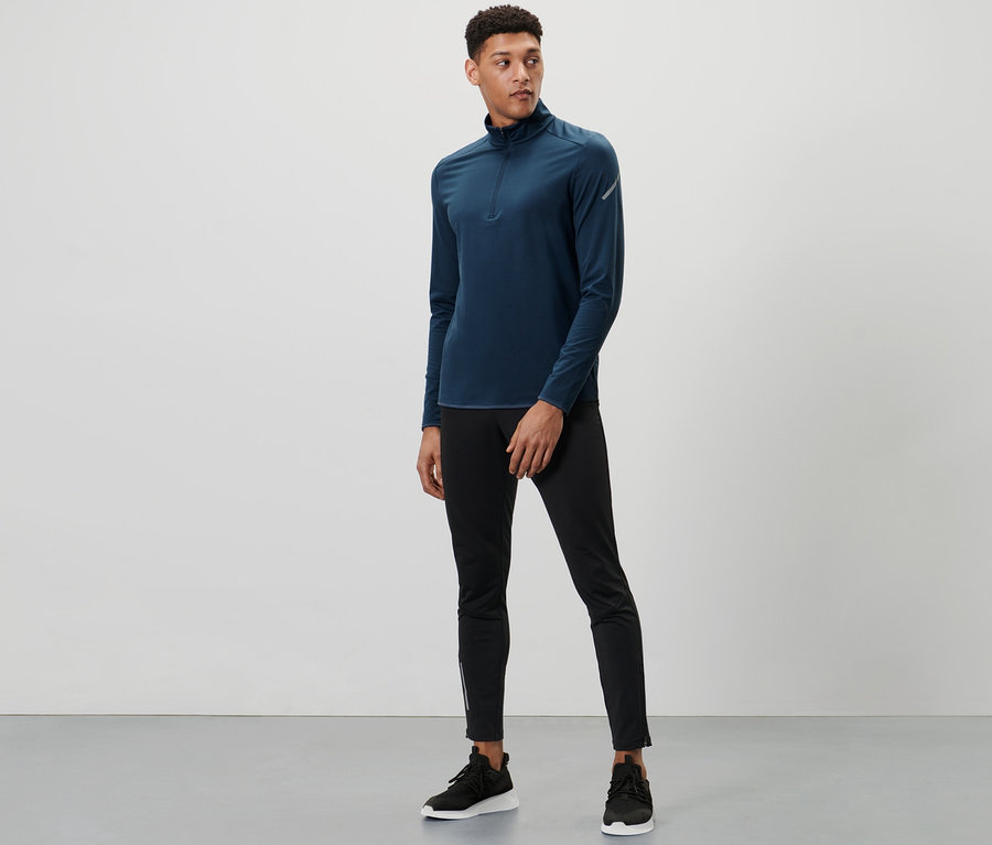 Mann steht und trägt ein blaues Thermo-Funktionsshirt.