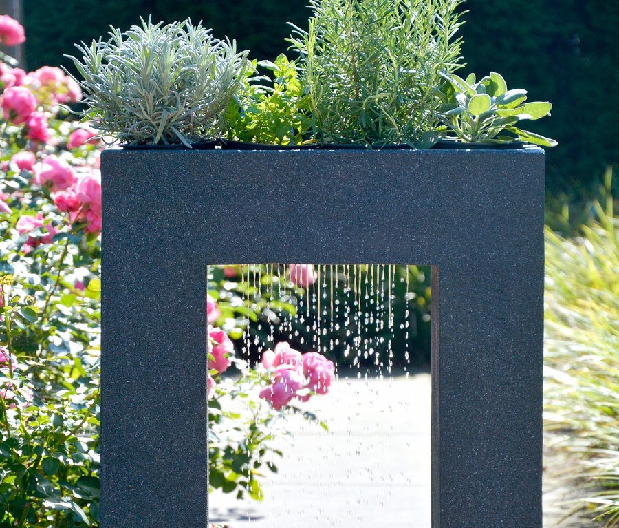 Dobar Gartenbrunnen mit Pflanzen-Option: Schwarzer Gartenbrunnen mit Wasserspiel, bepflanzt mit diversen Pflanzen.