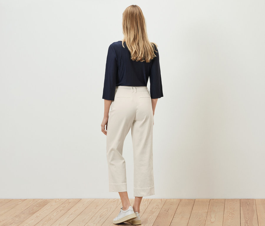 Eine Frau von hinten, trägt eine Flared Jeans – Fit »Cara«.