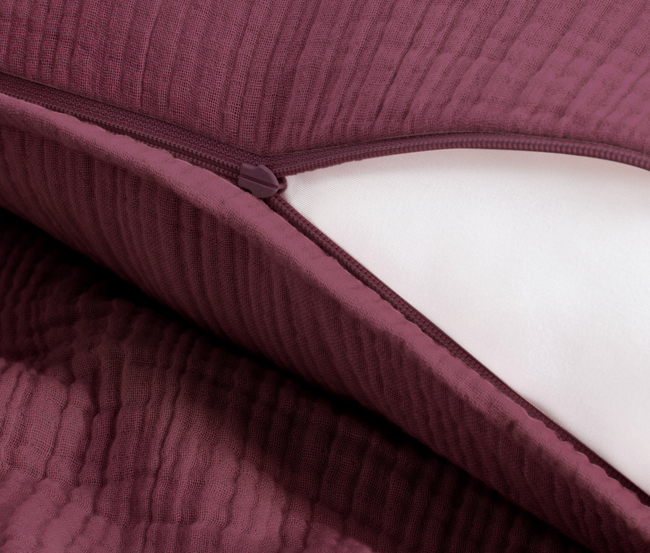 Nahaufnahme von beerefarbener Musselin-Bettwäsche in Normalgröße mit Reißverschluss.