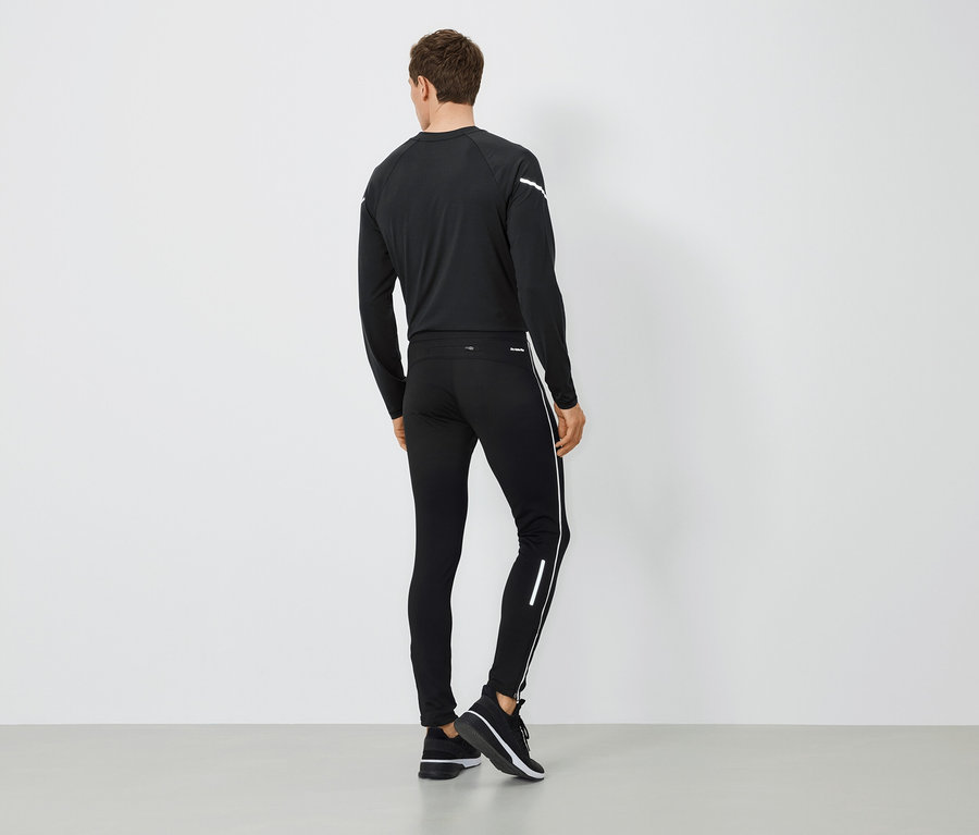 Mann von hinten trägt schwarze Sportbekleidung.