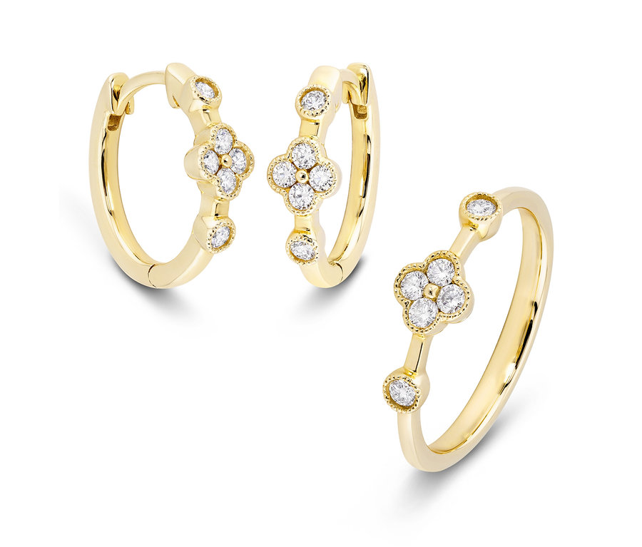 Goldene Creolen und goldener Ring mit Diamanten auf weißem Hintergrund.