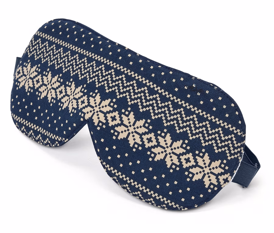 Blaue Schlafmaske mit Schneeflockenmuster auf weißem Hintergrund.