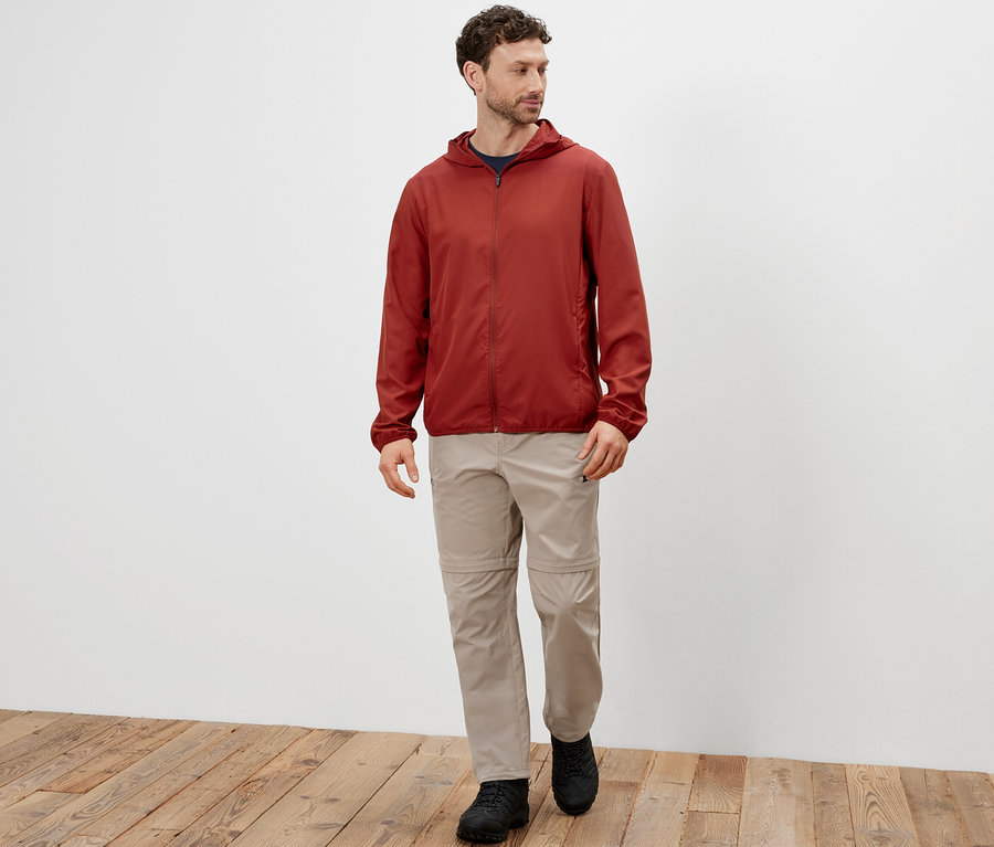 Mann geht und trägt eine Packpare Funktionsjacke.