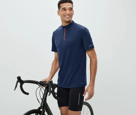 Mann neben Fahrrad trägt ein Fahrrad-Trikot.