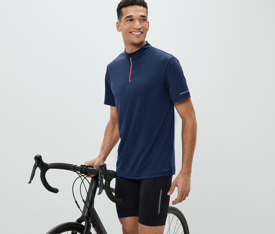 Mann neben Fahrrad trägt ein Fahrrad-Trikot.