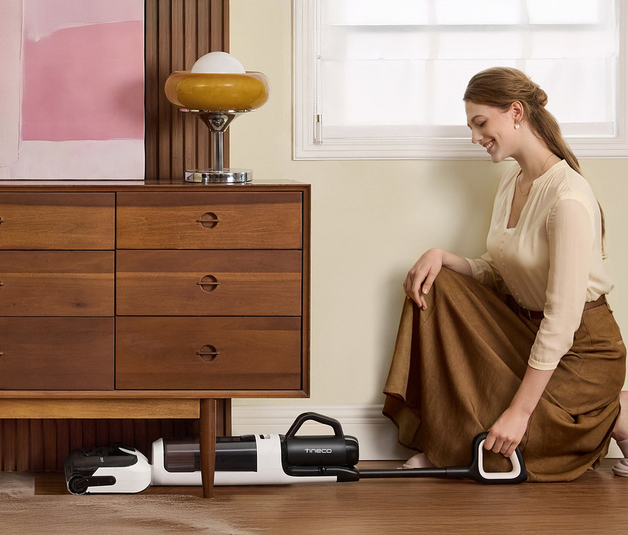 Frau hockt auf dem Boden und bedient einen Tineco Nass-Trockensauger »Floor One Switch i5 Stretch«.