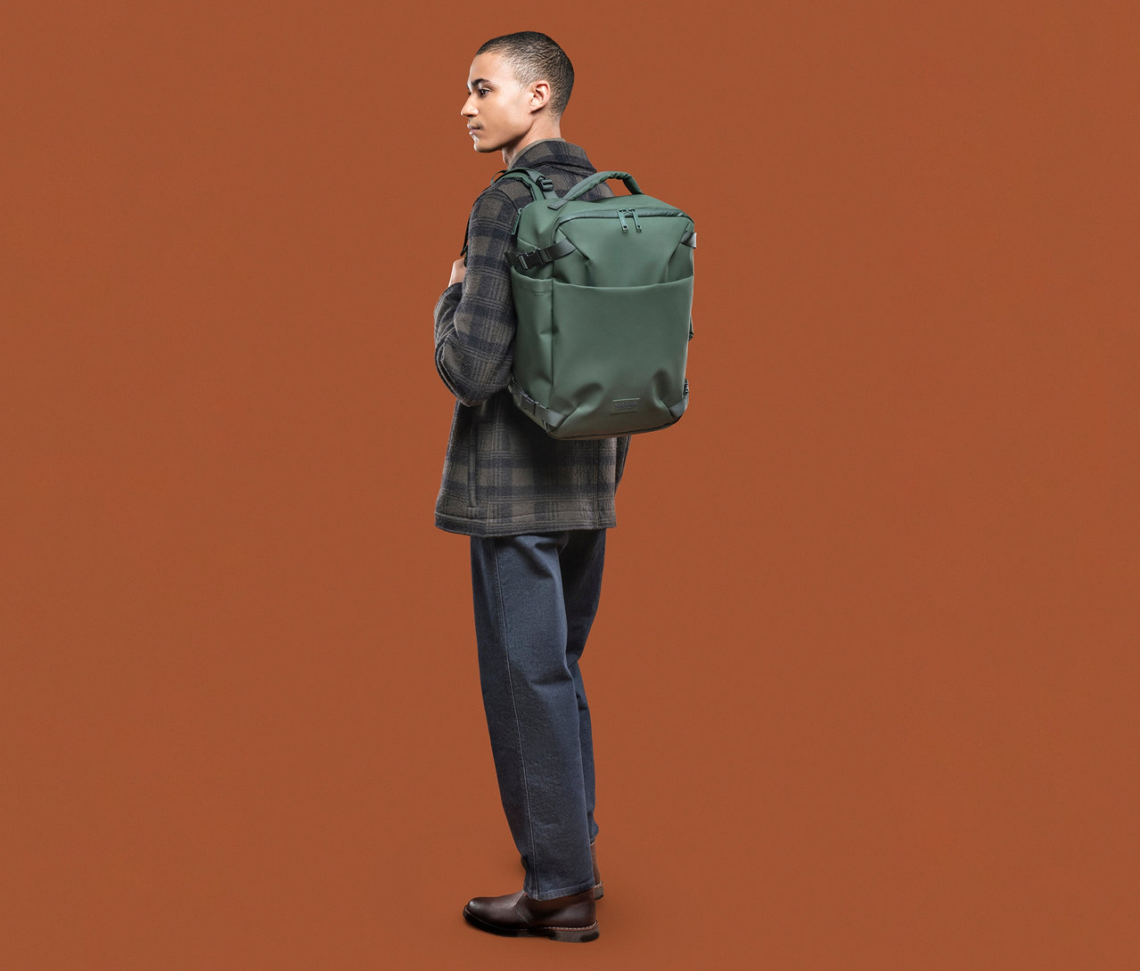 Mann mit Tucano TUGO DRY Kabinenrucksack mit 15,6"-Laptopfach in Grün.