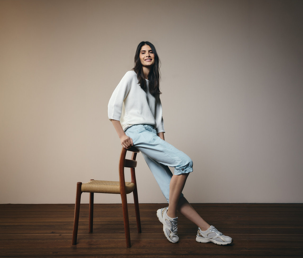 Frau lehnt an einem Stuhl und trägt hellblaue Cecil 3/4-Hose »New York« und einen weißen Pullover.