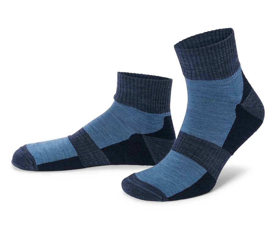 Zwei blaue Socken mit dunklen Akzenten stehen auf einem weißen Hintergrund.