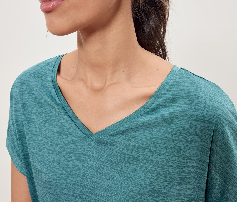 Nahaufnahme einer Frau, die ein türkisfarbenes V-Ausschnitt-T-Shirt trägt.