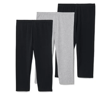Drei Leggings, zwei schwarz und eine grau, liegen nebeneinander.