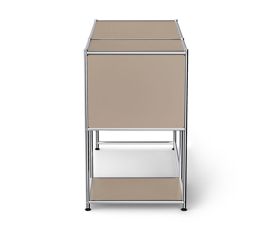 Beiger Modulschrank mit Chromrahmen, bestehend aus einem geschlossenen Oberteil und einem offenen Unterregal, auf weißem Hintergrund.