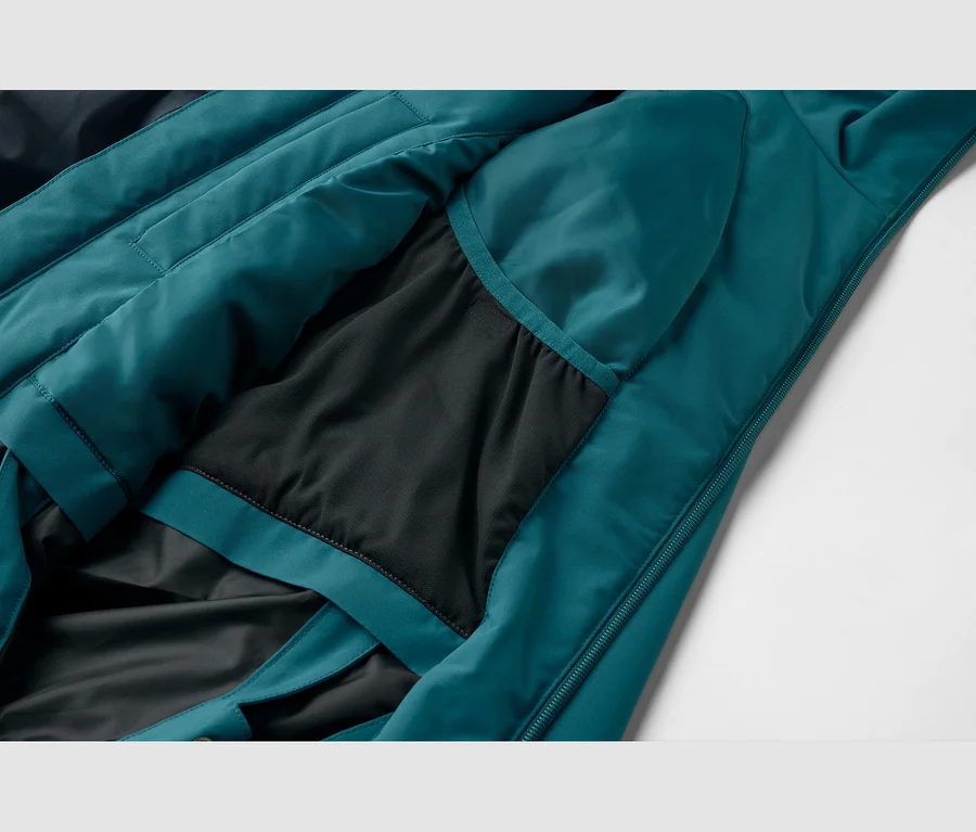 Nahaufnahme einer tealfarbenen Jacke mit schwarzem Innenfutter, einer inneren Netztasche und einem Reißverschluss.