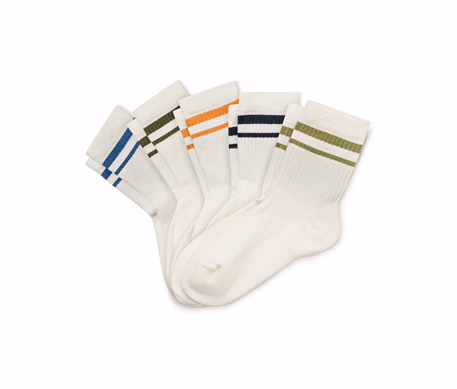 Fünf weiße Socken liegen gefächert nebeneinander, jede mit zwei farbigen Streifen am oberen Rand: blau, oliv, orange, dunkelblau und hellgrün.