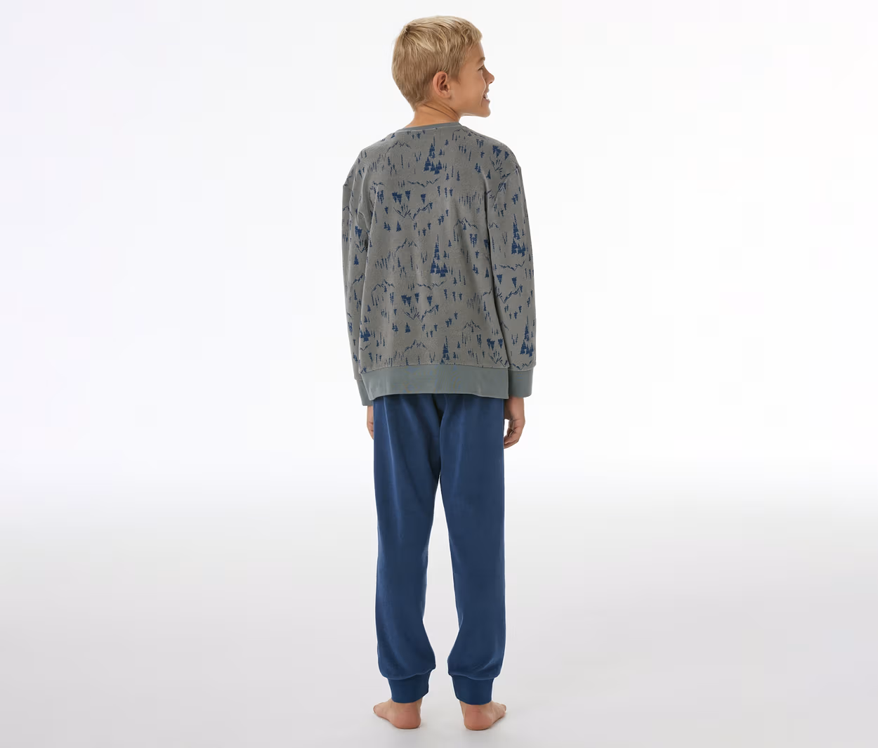 Junge von hinten in grauem SCHIESSER Kinder-Pyjama mit blauem Baummuster und blauer Hose mit Bündchen.