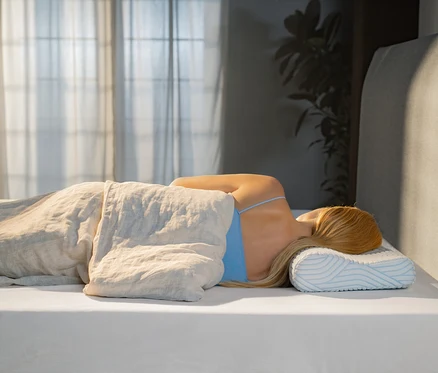 Frau schläft seitlich auf einem TEMPUR® Shape Queen SmartCool™ Kissen.