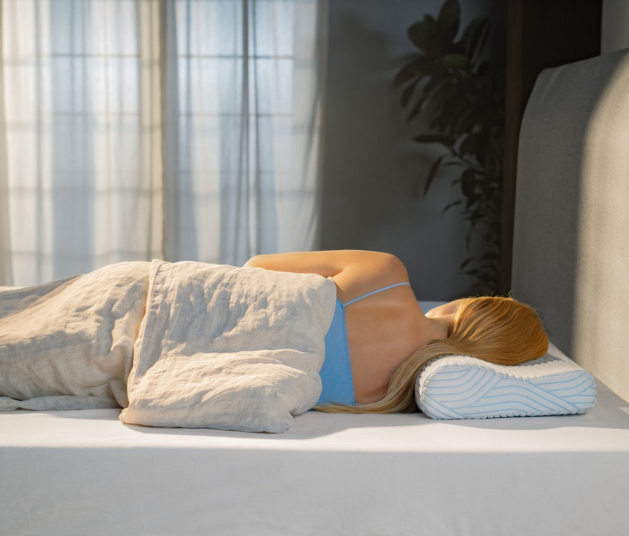 Frau schläft seitlich auf einem TEMPUR® Shape Queen SmartCool™ Kissen.