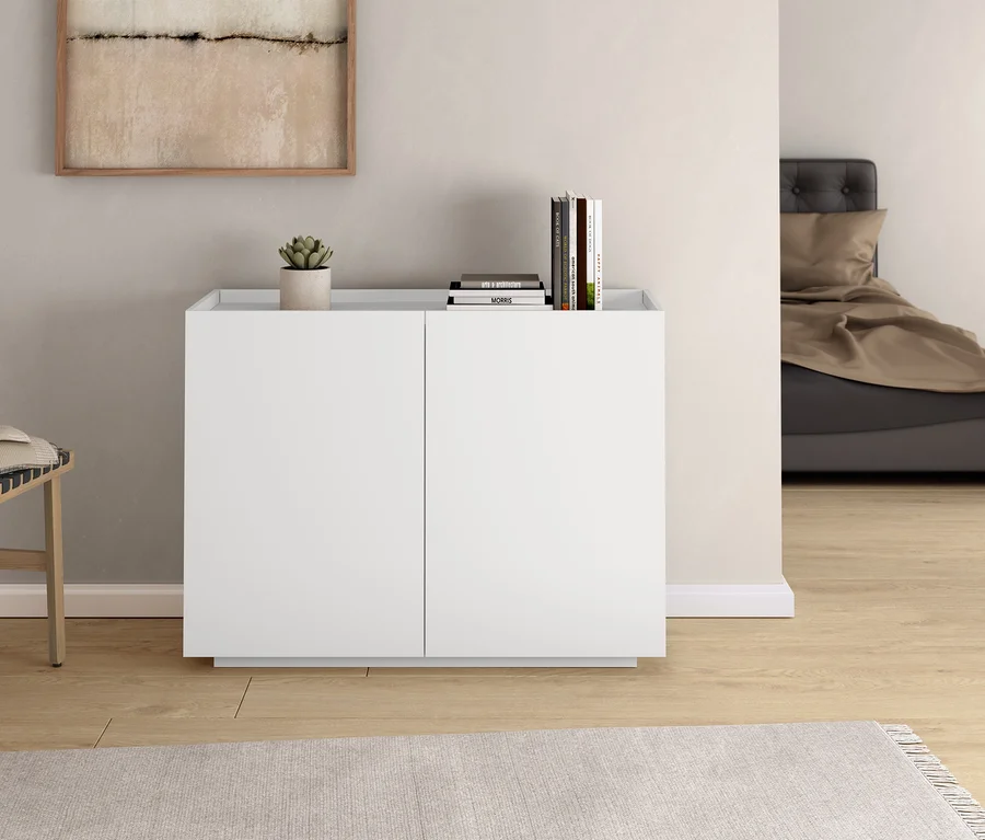 Im Zimmer stehen ein Hocker mit Geflecht, ein Schrank und ein anthrazitfarbenes Boxspringbett, ca. 180 x 200 cm.