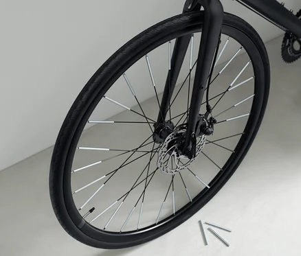 Nahaufnahme eines schwarzen Fahrrads mit 36 Speichen-Reflektoren an den Speichen.