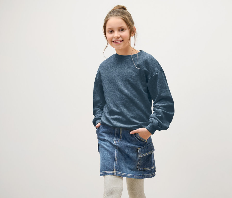 Mädchen posiert in blauem Kinder-Jeans-Rock.