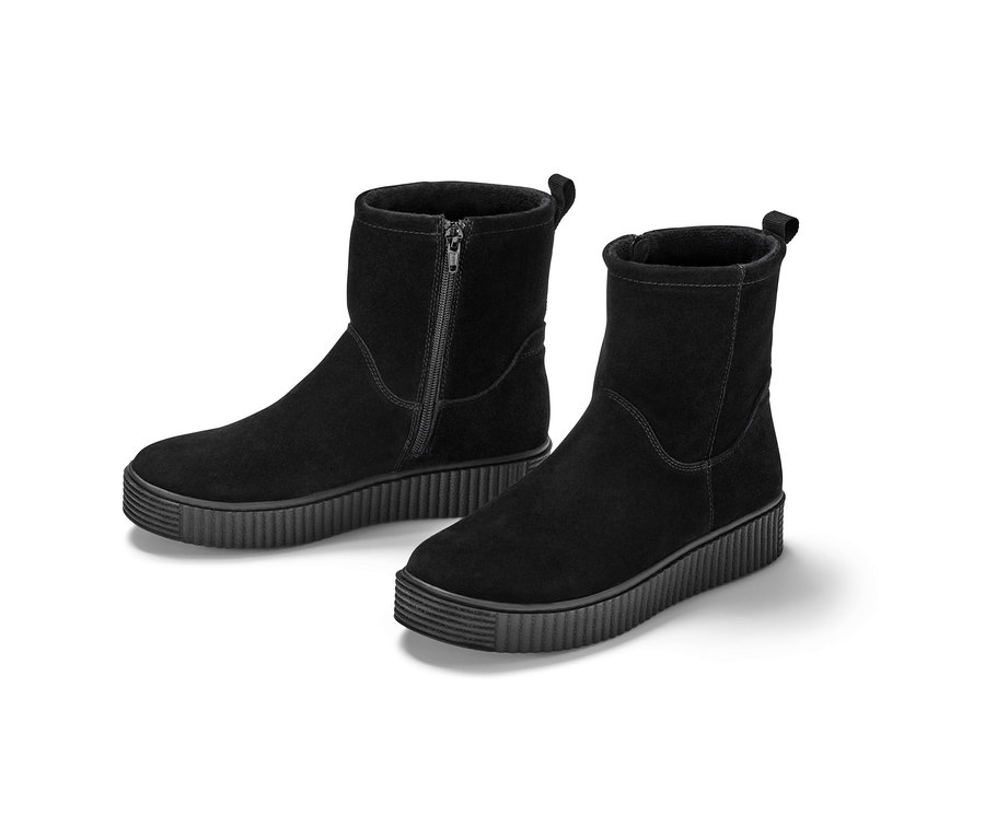 Zwei schwarze Veloursleder-Boots stehen vor einem weißen Hintergrund.