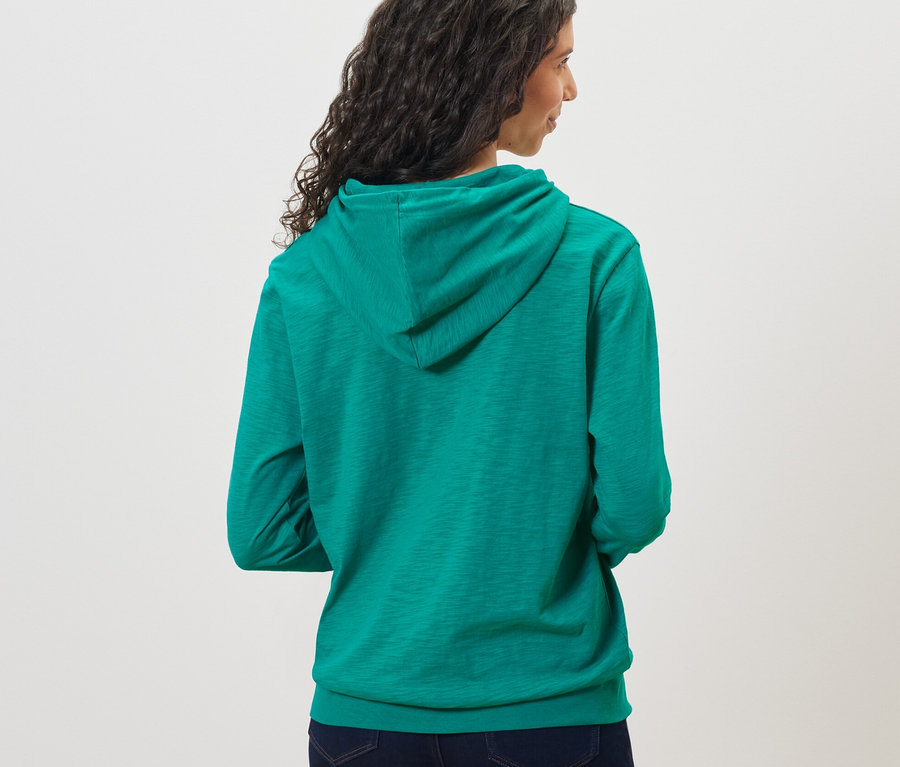 Frau trägt einen Aqua Jersey-Hoodie.