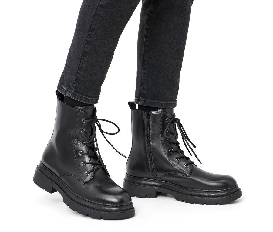 Beine in schwarzen Leder-Boots.