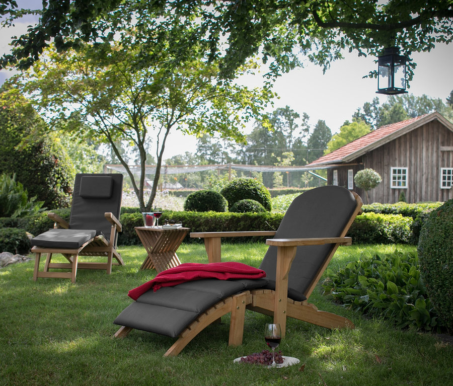 Zwei deVries Adirondack inkl. Auflage auf einer Wiese im Garten.