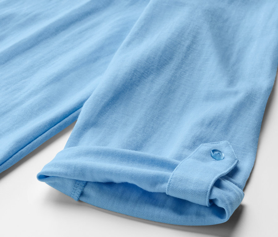 Detailansicht einer hellblauen Piqué-Jerseybluse mit hochgekrempeltem Ärmel.